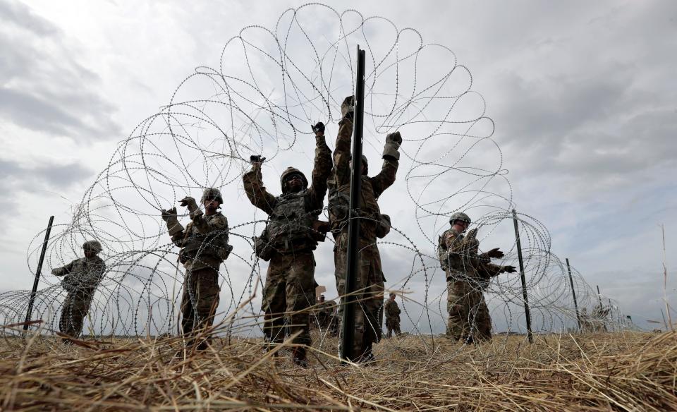 Members of a U.S Army engineering brigade place Concertina wire around an encampment for troops, Department of Defense and U.S. Customs and Border Protection near the U.S.-Mexico International bridge, Sunday, Nov. 4, 2018, in Donna, Texas. (AP Photo/Eric Gay)