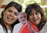 Supporters pose with a cut-out of Hindu nationalist Narendra Modi, the prime ministerial candidate for India's main opposition Bharatiya Janata Party (BJP), at a temple in the western Indian city of Ahmedabad May 15, 2014. REUTERS/Amit Dave