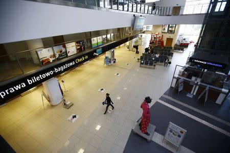 A woman walks in front of the check-in area at the airport in Lodz October 10, 2014. REUTERS/Kacper Pempel