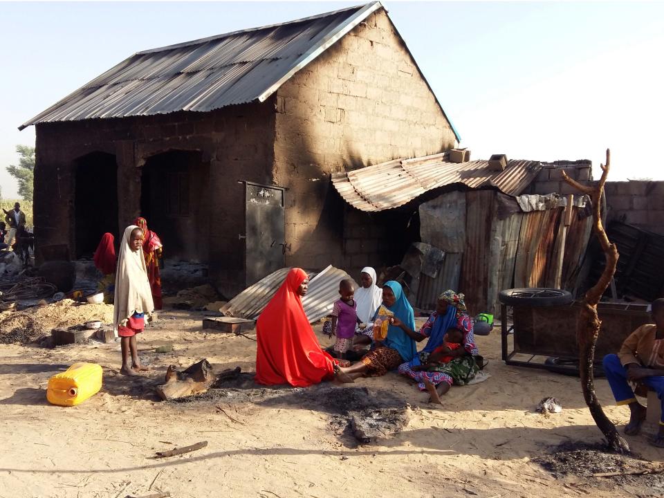 FILE PHOTO: People sit near a burnt house after an attack by suspected members of the Islamist Boko Haram insurgency in Bulabulin village, Nigeria November 1, 2018. REUTERS/Kolawole Adewale/File Photo