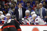 New York Rangers head coach Peter Laviolette, center left, watches a replay of a power play goal by Carolina Hurricanes' Brady Skjei during the third period in Game 4 of an NHL hockey Stanley Cup second-round playoff series in Raleigh, N.C., Saturday, May 11, 2024. (AP Photo/Karl B DeBlaker)