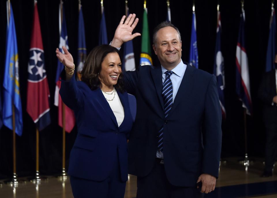 Democratic vice presidential running mate Kamala Harris and her husband Douglas Emhoff wave from the stage after the first Biden-Harris press conference in Wilmington, Delaware, on August 12, 2020.