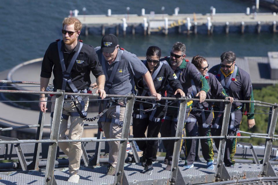 El príncipe Enrique de Inglaterra, a la izquierda, el primer ministro de Australia Scott Morrison, segundo de la izquierda, y representantes de los Juegos Invictus escalan el Puente de la Babía de Sydney el viernes 19 de octubre del 2018. Enrique y su esposa Meghan realizan una visita de 16 días a Australia y el Pacífico Sur. (AP Foto/Steve Christo, Pool)