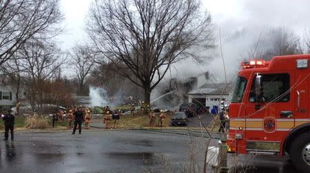 Smoke is seen after a small plane crashed in to a home and damaged others in Gaithersburg, Maryland, in this handout photo provided by the Montgomery County Fire & Rescue Service, December 8, 2014. REUTERS/Montgomery County Fire & Rescue Service/Handout