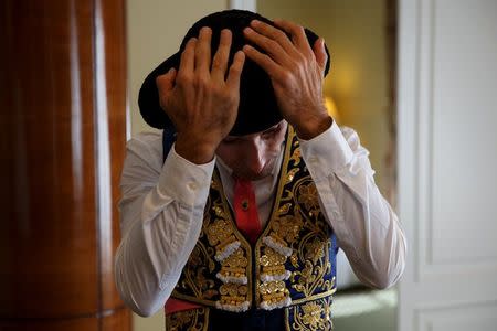 Alberto Lamelas adjusts his montera (bullfighter hat) in a hotel room before taking part in a bullfighting during San Isidro festival at Las Ventas bullring in Madrid, Spain, June 5, 2017. REUTERS/Sergio Perez