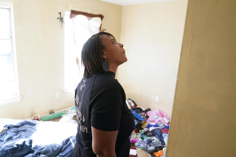 Angela Banks looks through an unkept bedroom in the house she used to rent, Wednesday, Feb. 15, 2023, in Baltimore. In 2018, Banks was told by her landlord that Baltimore officials were buying her family's home of four decades, planning to demolish the three-story brick rowhouse to make room for an urban renewal project aimed at transforming their historically Black neighborhood. Banks and her children became homeless almost overnight. Banks filed a complaint Monday asking federal officials to investigate whether Baltimore's redevelopment policies are perpetuating racial segregation and violating fair housing laws by disproportionately displacing Black and low-income residents. (AP Photo/Julio Cortez)