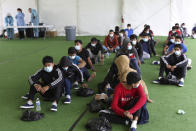 FILE - In this March 30, 2021 file photo, young migrants wait to be tested for COVID-19 at the Donna Department of Homeland Security holding facility, the main detention center for unaccompanied children in the Rio Grande Valley, in Donna, Texas. The Biden administration is holding tens of thousands of asylum-seeking children in an opaque network of some 200 facilities that The Associated Press has now learned spans two dozen states and includes five shelters with more than 1,000 children packed inside. (AP Photo/Dario Lopez-Mills, Pool, File)