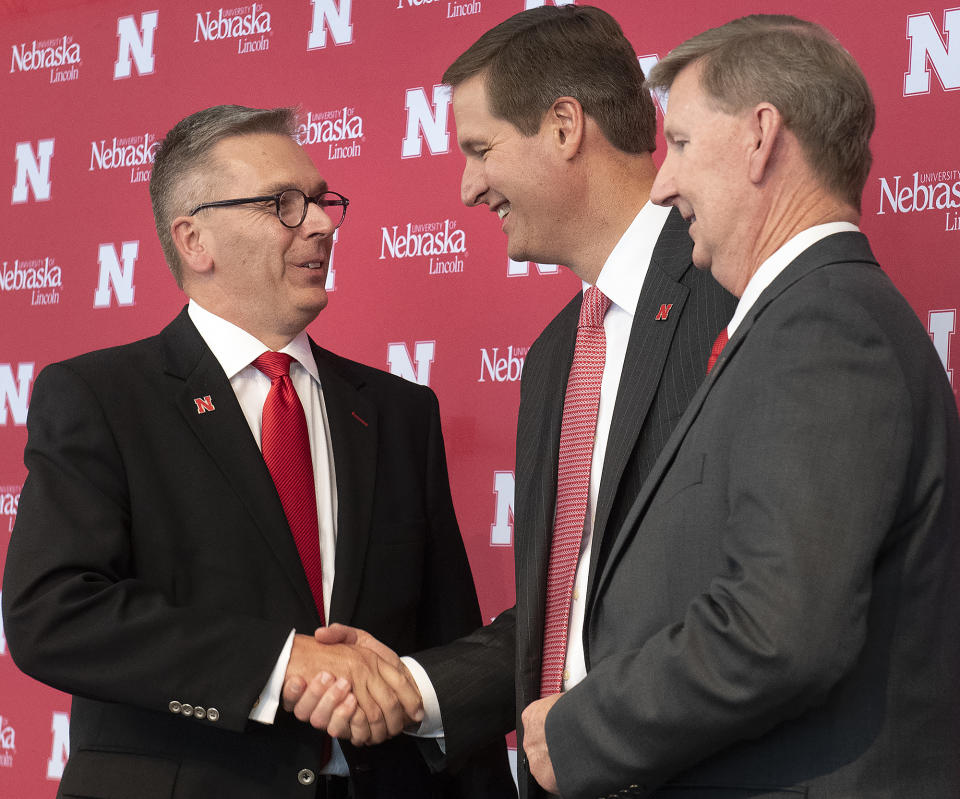 University of Nebraska Chancellor Ronnie Green, left, shakes hands with Trev Alberts, center, as NU President Ted Carter looks on during a during a news conference where Alberts was introduced as Nebraska's new athletic director, Wednesday, July 14, 2021, at Memorial Stadium in Lincoln, Neb. (Gwyneth Roberts/Lincoln Journal Star via AP)