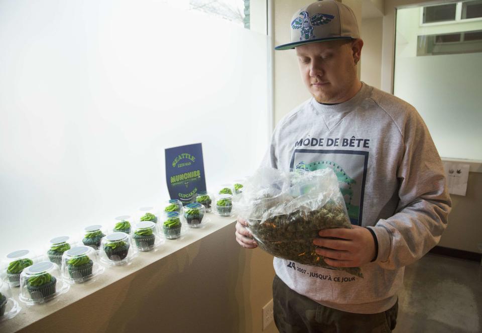 Nate Johnson, managing owner of the Queen Anne Cannabis Club, carries a bag of a marijuana strain called "Beast Mode OG", named after NFL player Marshawn "Beast Mode" Lynch of the Seattle Seahawks, in Seattle, Washington January 28, 2014. For Nate Johnson, the excitement surrounding the upcoming Super Bowl is two-fold. Not only are his hometown Seattle Seahawks taking on the Denver Broncos - football teams representing two major U.S. cities where recreational pot use is legal - but his medical weed dispensary is seeing green. Demand for "Beast Mode" - a strain named in honor of the Seahawks' hard-hitting running back, Marshawn Lynch - has been high at his Queen Anne Cannabis Club in Seattle, Johnson said, while pot-laced blue-and-green cupcakes are also selling fast. REUTERS/Jason Redmond (UNITED STATES - Tags: DRUGS SOCIETY BUSINESS SPORT FOOTBALL FOOD)