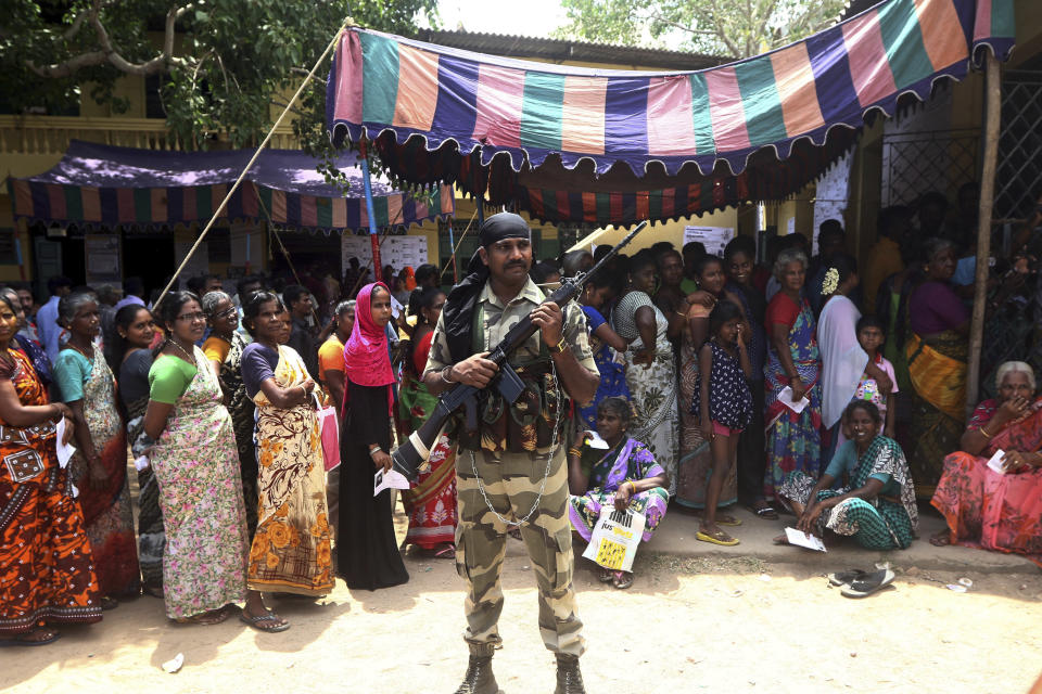 A soldier stands guard as Indians wait in a queue to cast their votes during the second phase of India's general elections in Chennai, India, Thursday, April 18, 2019. The Indian election is taking place in seven phases over six weeks in the country of 1.3 billion people. Some 900 million people are registered to vote for candidates to fill 543 seats in India's lower house of Parliament. (AP Photo/R. Parthibhan)
