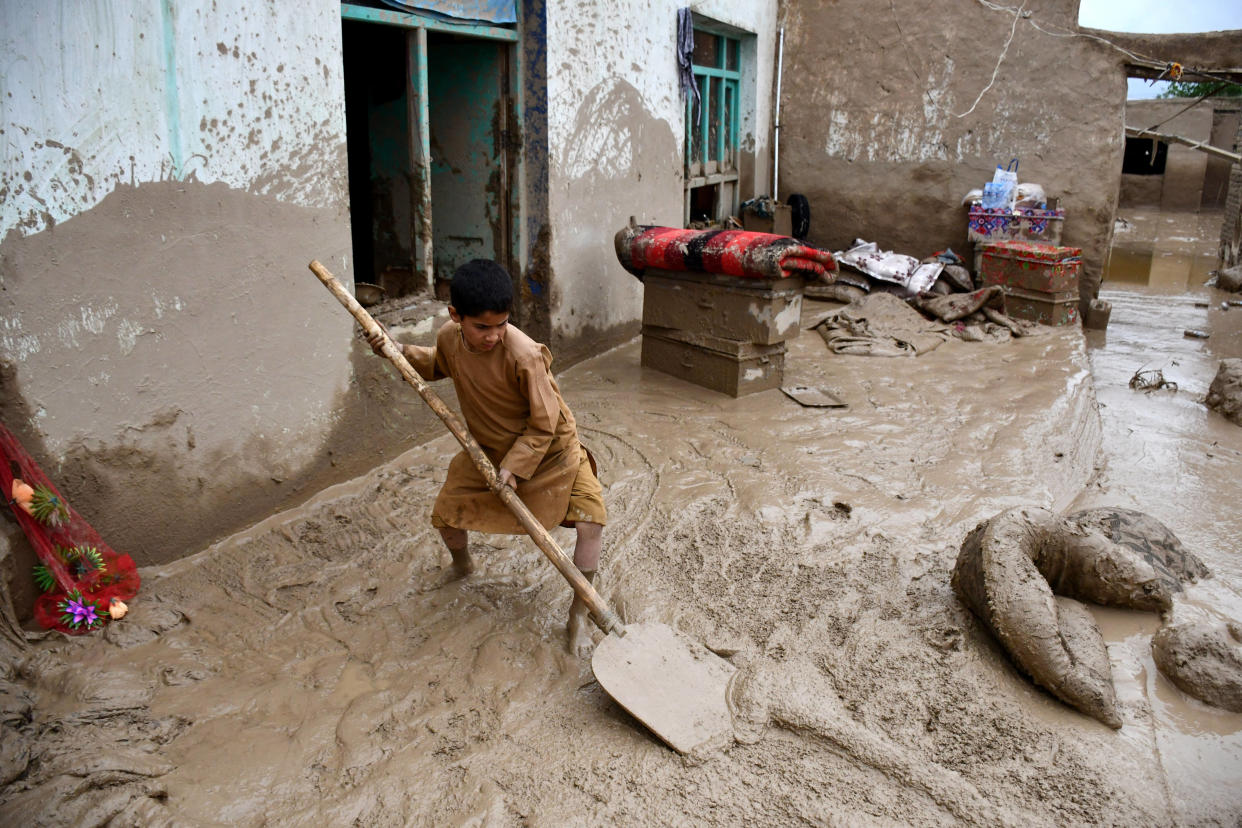 Un garçon afghan retire la boue de la cour d’une maison après des inondations soudaines dans la province de Baghlan, le 11 mai 2024. 