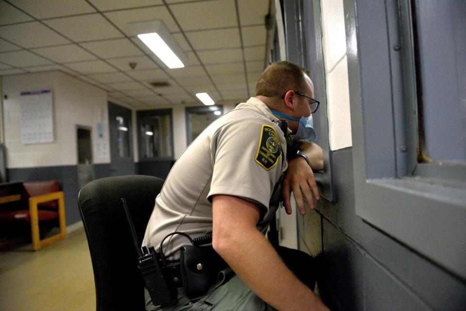 Corrections Officer Jonathan Childs looks at an inmate who was on a round-the-clock watch at the Rockingham County Department of Corrections in Brentwood on Sept. 21, 2022.