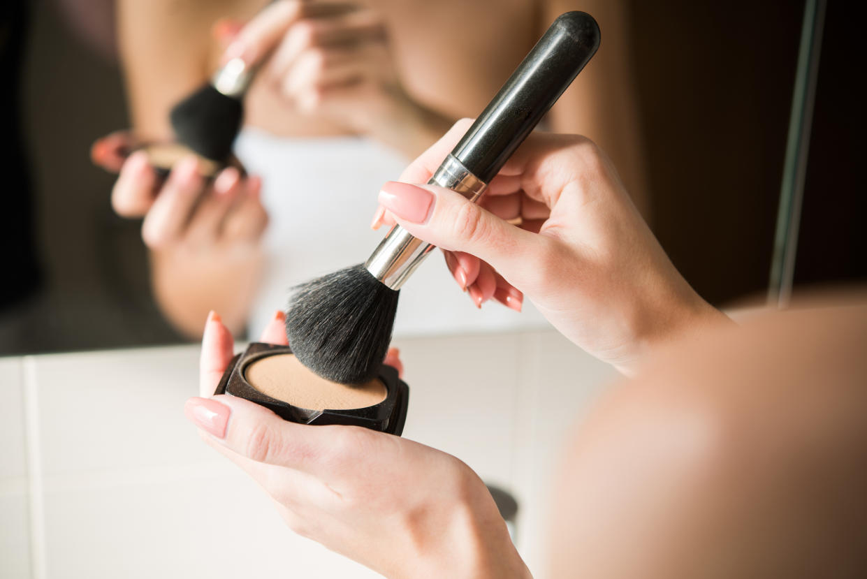 Using make-up brush with powder. (Getty Images)