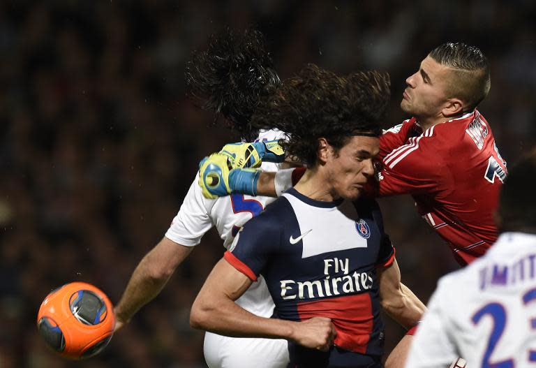 Lyon's goalkeeper Miguel Lopes (R) punches the ball away during the match against Paris Saint-Germain at the Gerland stadium in Lyon, central-eastern France, on April 13, 2014