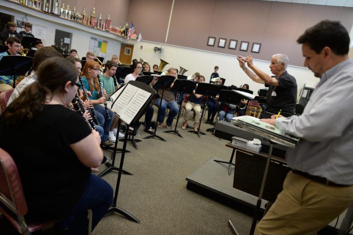 Leesburg High School Band director Gabriel Fielder, foreground right, jots notes as guest conductor Joe Kreines, a member of the Florida Bandmasters Association Hall of Fame, leads a band practice at LHS in 2014.