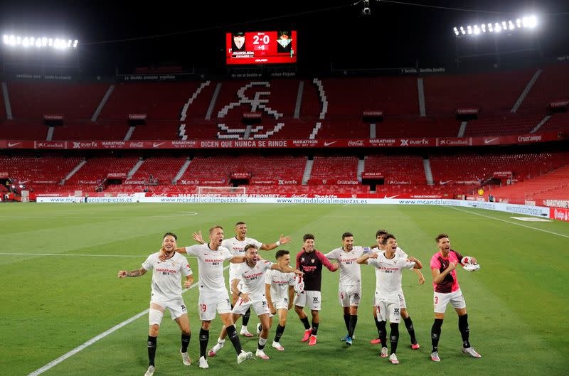 Los jugadores del Sevilla celebran tras ganar el derbi ante Real Betis en el regreso de La Liga española de fútbol, en un partido jugado sin público debido al brote de coronavirus, en el estadio Ramón Sánchez Pisjuan, en Sevilla, España