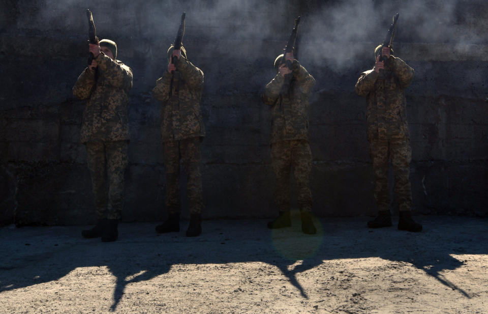 Ukrainian soldiers fire a gun salute.