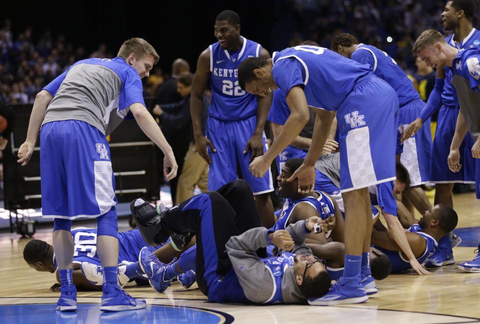 Kentucky players celebrate after an NCAA Midwest Regional final college basketball tournament game against Michigan Sunday, March 30, 2014, in Indianapolis. Kentucky won 75-72 to advance to the Final Four. (AP Photo/David J. Phillip)