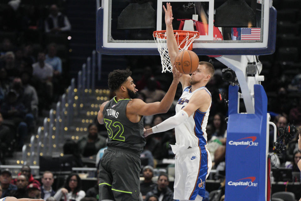 Minnesota Timberwolves center Karl-Anthony Towns (32) passes in front of Washington Wizards center Kristaps Porzingis, right, during the first half of an NBA basketball game, Monday, Nov. 28, 2022, in Washington. (AP Photo/Jess Rapfogel)