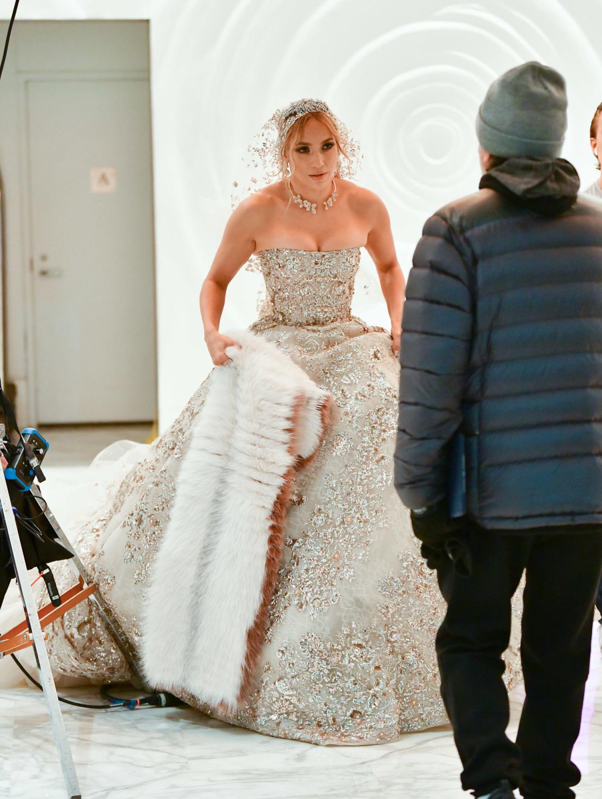 Jennifer Lopez’s wedding isn’t here just yet, despite the singer and actress being a vision in white on Oct. 17, 2019 while filming her new movie “Marry Me”. Lopez, donning a jewel-encrusted gown with a flowing tulle train, was spotted filming scenes at the Atelier Condo Building in New York on Thursday.