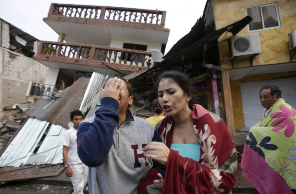 Woman cries outside her home