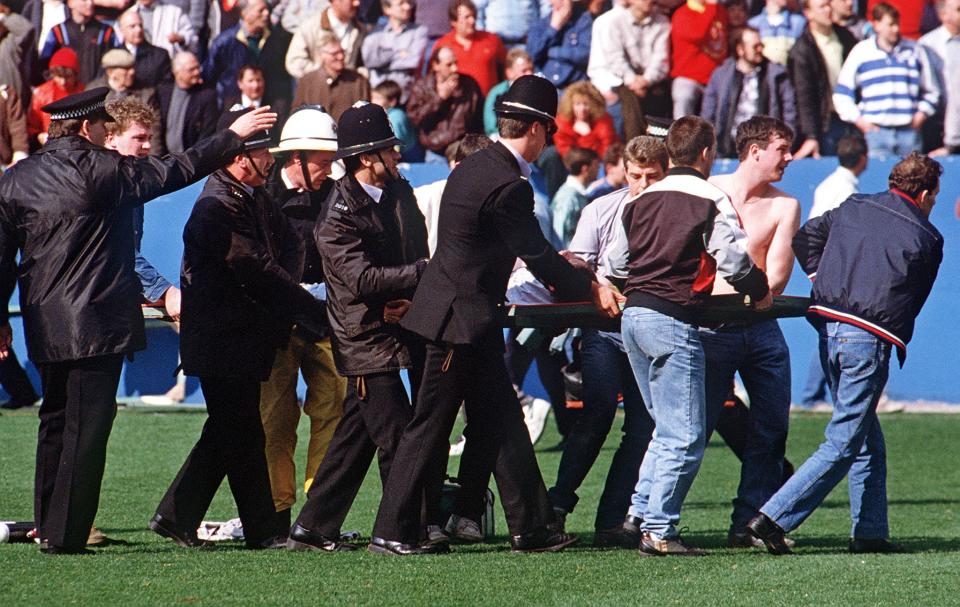 An injured fan is stretchered off the pitch during the Hillsborough disaster in 1989