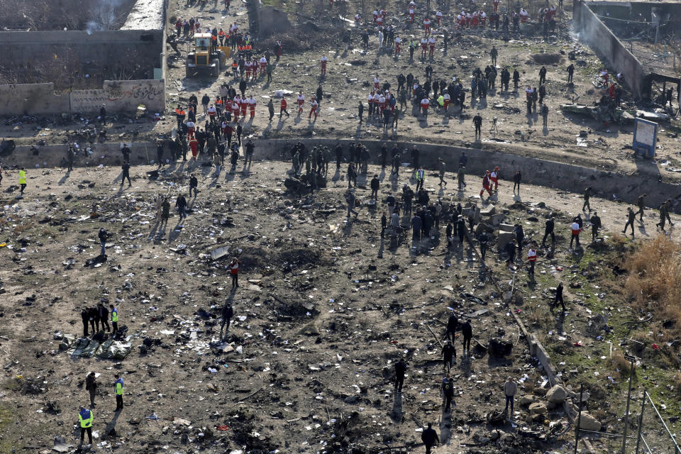 Rescue workers search the scene where a Ukrainian plane crashed in Shahedshahr southwest of the capital Tehran, Iran, Wednesday, Jan. 8, 2020. A Ukrainian airplane with more than 170 people crashed on Wednesday shortly after takeoff from Tehran's main airport, killing all onboard. (AP Photo/Ebrahim Noroozi)