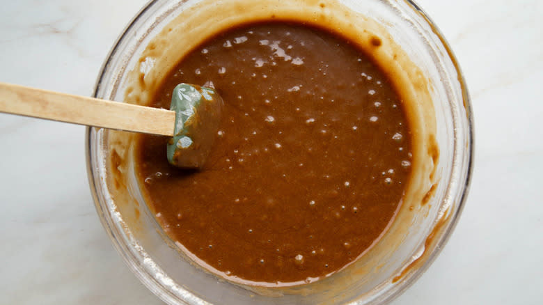 molasses cake batter in clear bowl with whisk