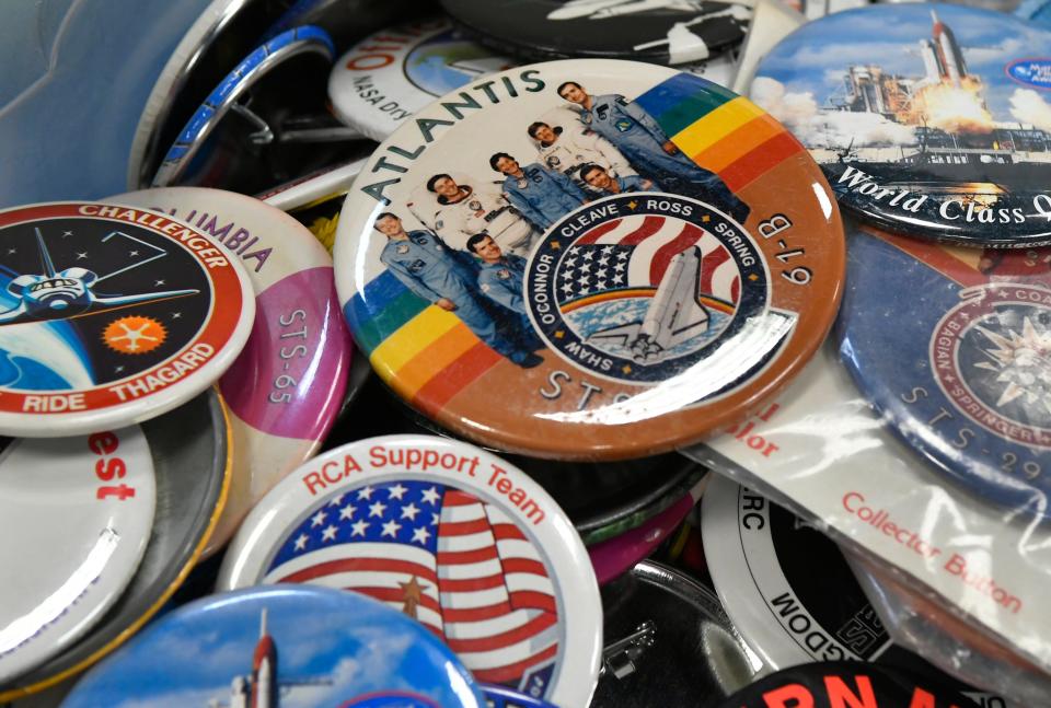 A space shuttle Atlantis button sits atop a stack of buttons at the Space Collectibles Show and Sale.