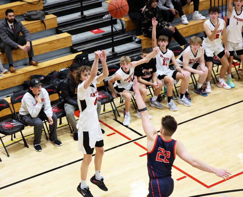 Whitman-Hanson's Cole Champignie hits a three-point basket over Pembroke defender Brady Spencer during a game on Tuesday, Dec. 13, 2022.