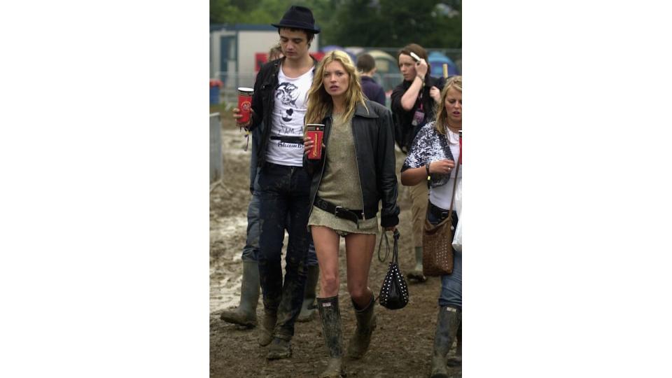  Kate Moss attends Glastonbury in 2005 wearing a gold dress, wellington boots and a leather jacket