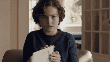 Will from Brahms The Boy 2 holding up a handwritten paper that says I'd like to go now