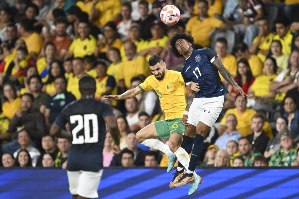 Aziz Behich of Australia and Angelo Preciado, right, of Ecuador battle for the ball during a friendly soccer international between Ecuador and Australia in Sydney, Friday, March 24, 2023. (Dean Lewins/AAPImage via AP)