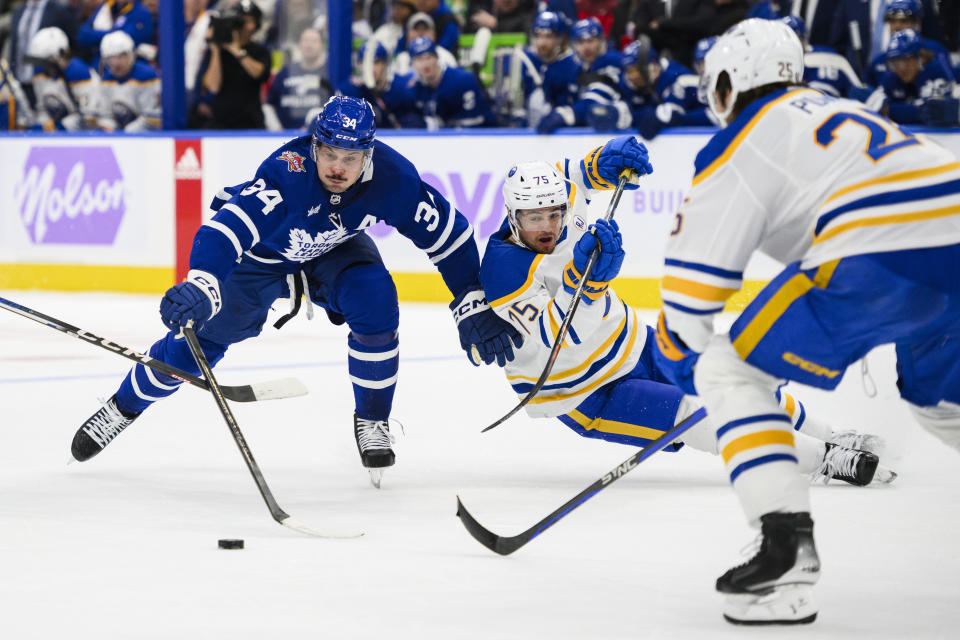 Toronto Maple Leafs center Auston Matthews (34) is defended by Buffalo Sabres defenseman Connor Clifton (75) and defenseman Owen Power (25) during the second period of an NHL hockey game Saturday, Nov. 4, 2023, in Toronto. (Christopher Katsarov/The Canadian Press via AP)