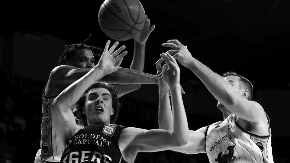 WOLLONGONG, AUSTRALIA - MAY 11:  (EDITORS NOTE: Image has been converted to black and white.) Josh Giddey of the 36ers competes for the ball with Justin Simon and AJ Ogilvy of the Hawks  during the round 18 NBL match between the Illawarra Hawks and Adelaide 36ers at WIN Entertainment Centre, on May 11, 2021, in Wollongong, Australia. (Photo by Mark Kolbe/Getty Images) ORG XMIT: 775644797 ORIG FILE ID: 1317432450