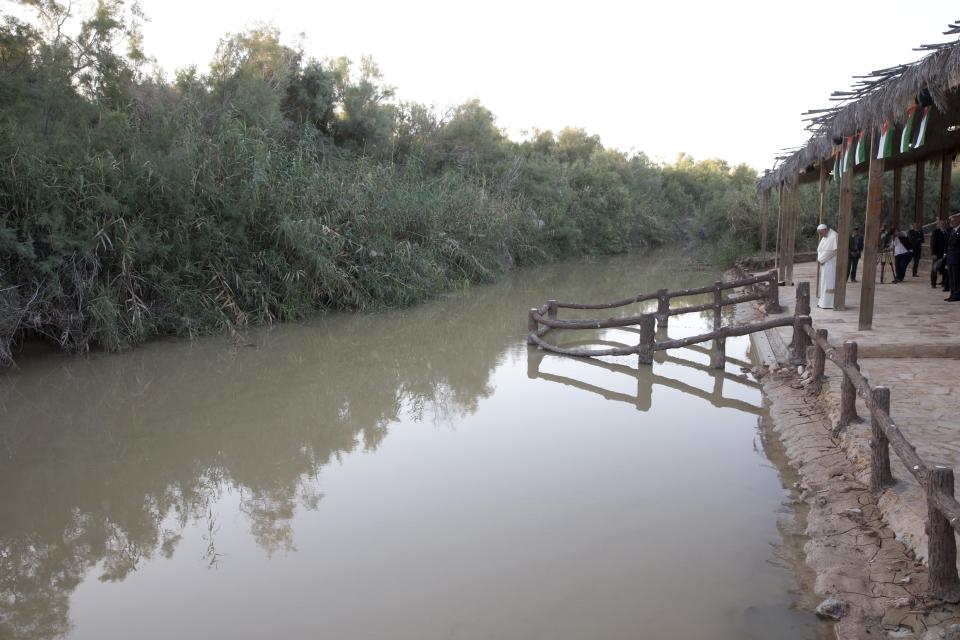 FILE - Pope Francis prays in front of the Jordan River at the Bethany beyond the Jordan baptismal site on the east bank of the river, west of Amman, Jordan, on Saturday, May 24, 2014. The Bible says Jesus was baptized in the Jordan River. (AP Photo/Andrew Medichini, Pool, File)