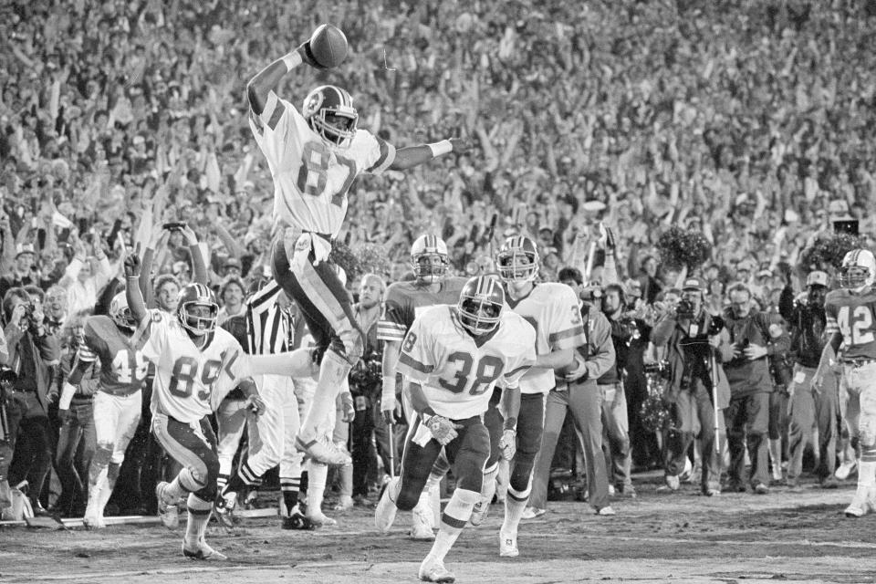 FILE - Washington Redskins receiver Charlie Brown (87) gets ready to spike the ball after he scored a fourth quarter touchdown against the Miami Dolphins in Super Bowl XVII in Pasadena, Calif., Jan. 30, 1983. Coming over to congratulate Brown are teammates Alvin Garrett (89) and Clarence Harmon (38). Washington beat Miami 27-17. Few NFL teams have managed to lose as much as Washington has since Daniel Snyder was part of a group that purchased the franchise for a then-record $800 million in 1999. (AP Photo/File)