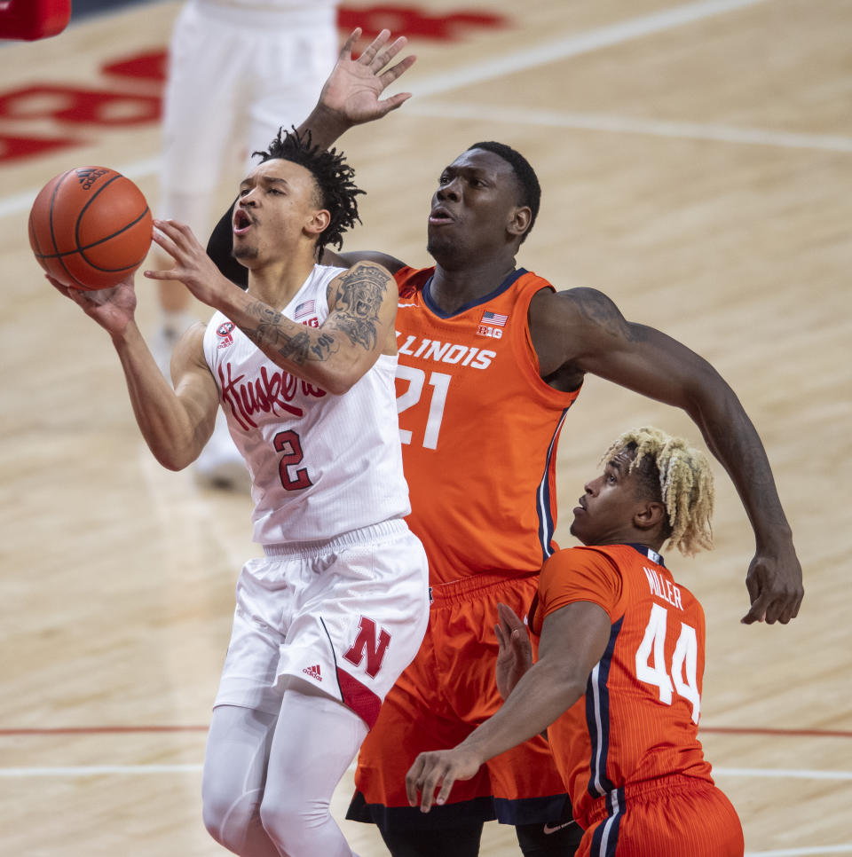 Nebraska guard Trey McGowens (2) drives to the basket against Illinois' Kofi Cockburn (21) and Adam Miller (44) during the first half of an NCAA college basketball game on Friday, Feb. 12, 2021, in Lincoln, Neb. (Francis Gardler/Lincoln Journal Star via AP)