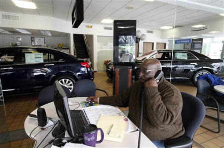 Car salesman Leo Emerson sits at his desk surrounded by a Chrysler 200 Limited and 300 at Bill Snethkamp dealership in Detroit, Michigan January 2, 2014. REUTERS/Joshua Lott