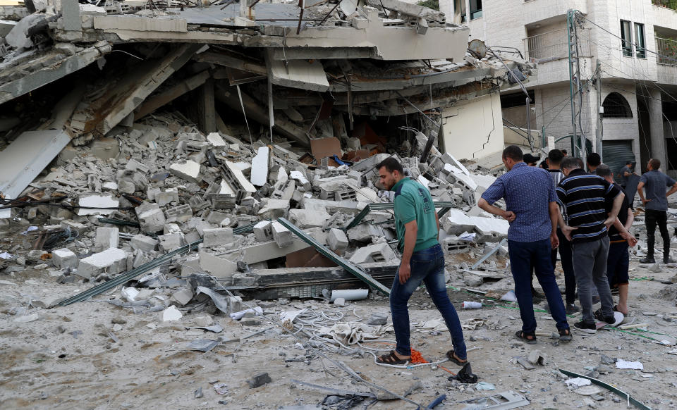 People inspect the rubble of destroyed residential building that was hit by an Israeli airstrike, in Gaza City, Monday, May 17, 2021. (AP Photo/Adel Hana)