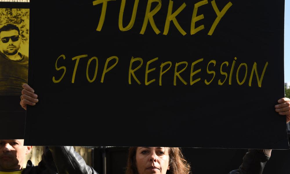 A woman holds a sign highlighting Turkey’s detention of human rights activists at a protest in Paris on 20 July.