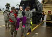 <p>Texas Army National Guard members Sergio Esquivel, left, and Ernest Barmore carry 81-year-old Ramona Bennett after she and other residents were rescued from their Pine Forest Village neighborhood due to high water from Hurricane Harvey August 29, 2017 in Houston, Texas. Harvey, which made landfall north of Corpus Christi late Friday evening, is expected to dump upwards to 40 inches of rain in areas of Texas over the next couple of days. (Photo: Erich Schlegel/Getty Images) </p>