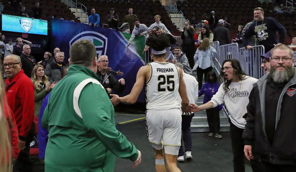 Akron Zips forward Enrique Freeman (25) runs back into the locker room after beating Ohio in the MAC Tournament semifinals Friday in Cleveland.