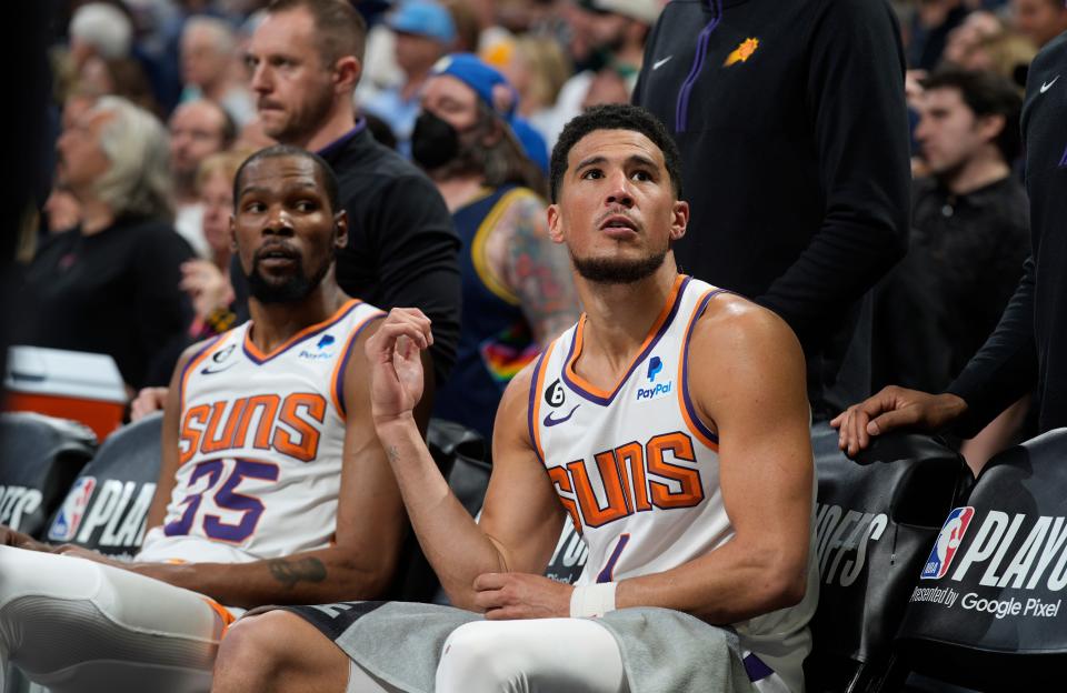 Phoenix Suns guard Devin Booker, front, and forward Kevin Durant check the clock during a time out late in the second half of Game 2 of an NBA second-round playoff series against the Denver Nuggets Monday, May 1, 2023, in Denver.