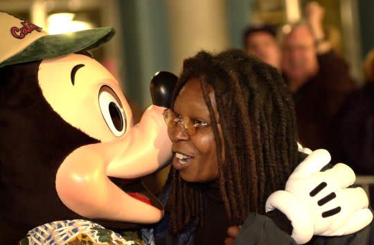 Comedian and actress Whoopi Goldberg gets a kiss from Mickey Mouse as she arrives to a V.I.P. party on the eve of the public grand opening of ''Disney's California Adventure'' theme park, February 7, 2001 in Anaheim, CA. The 55-acre park next to Disneyland is based upon California themes of past and present. (Photo by David McNew/Newsmakers)
