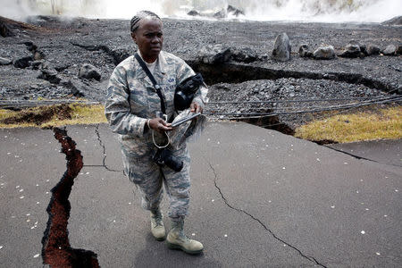 Technical Sergeant Alison Bruce-Maldonado of the Hawaii National Guard documents road damage in Leilani Estates during ongoing eruptions of the Kilauea Volcano in Hawaii, U.S., May 18, 2018. REUTERS/Terray Sylvester