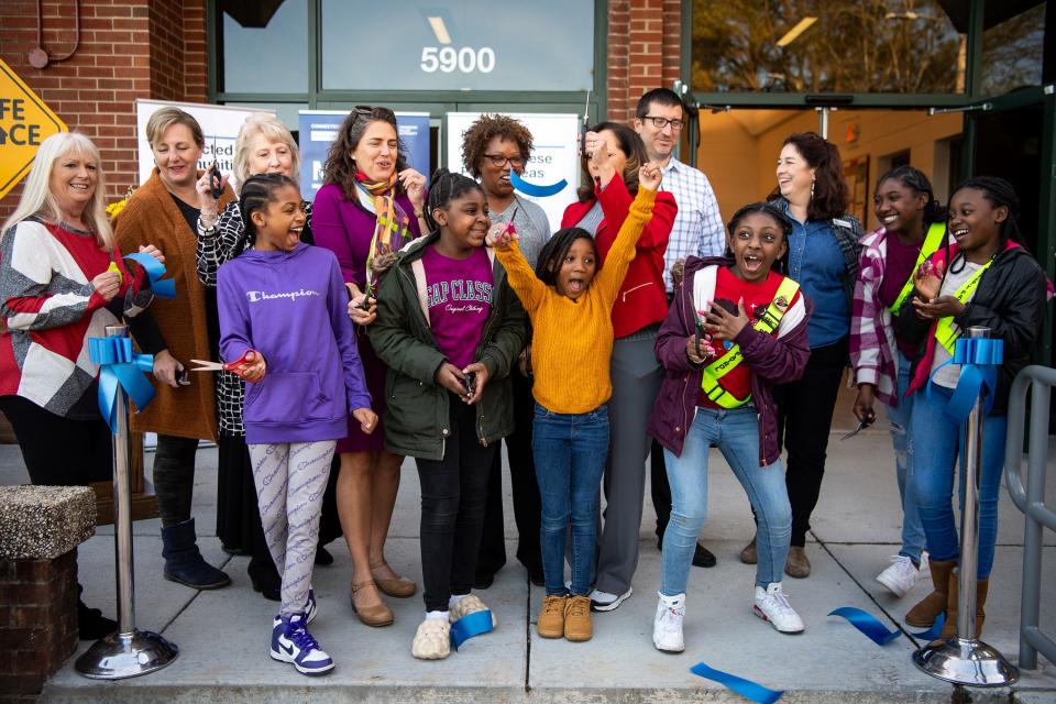 Children celebrate after they help city leaders cut the ribbon on the newly renovated Milton S. Roberts Community Center on Asheville Highway.