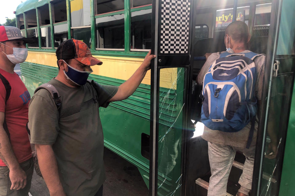 Expelled migrants board a city bus in Tijuana, Mexico, Oct. 8, 2020. President Donald Trump’s reshaping of U.S. immigration policy may be most felt in his undoing of asylum. With immigration laws temporarily suspended at the border during the pandemic, people who enter the U.S. illegally are immediately “expelled” without even a piece of paper to record the incident. (AP Photo/Elliot Spagat)