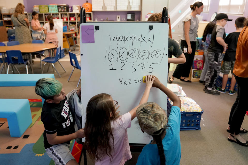 Students at Whittier Elementary School work in groups and independently, Tuesday, Oct. 18, 2022 in Mesa, Ariz. Like many school districts across the country, Mesa has a teacher shortage due in part due to low morale and declining interest in the profession. Five years ago, Mesa allowed Whittier to participate in a program making it easier for the district to fill staffing gaps, grant educators greater agency over their work and make teaching a more attractive career. The model, known as team teaching, allows teachers to combine classes and grades rotating between big group instruction, one-on-one interventions, small study groups or whatever the team agrees is a priority each day. (AP Photo/Matt York)