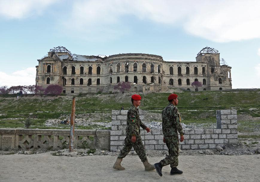 Afghan national army soldiers walk past the palace of the late King Amanullah Khan, which was destroyed during the civil war in early 1990s, in Kabul, Afghanistan, Sunday, April 27, 2014. (AP Photo/Rahmat Gul)